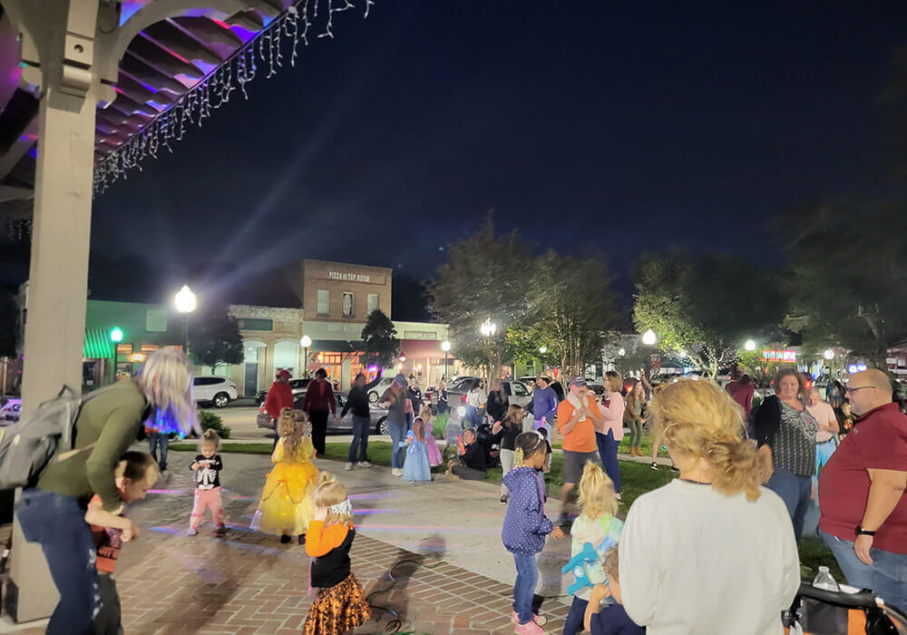 Families gathered under string lights in Hutchinson Square on a Third Thursday evening